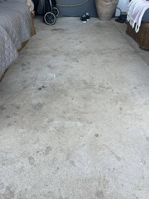 Worn, stained bare concrete garage floor in Maui before a protective coating